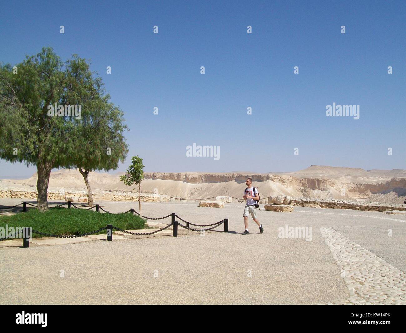 At the gravesite of David Ben-Gurion, founder of the country of Israel, and his wife Paula Ben-Gurion, an off-duty Israel soldier walks towards a small patch of trees, Negev Desert, Israel, 2012. Stock Photo