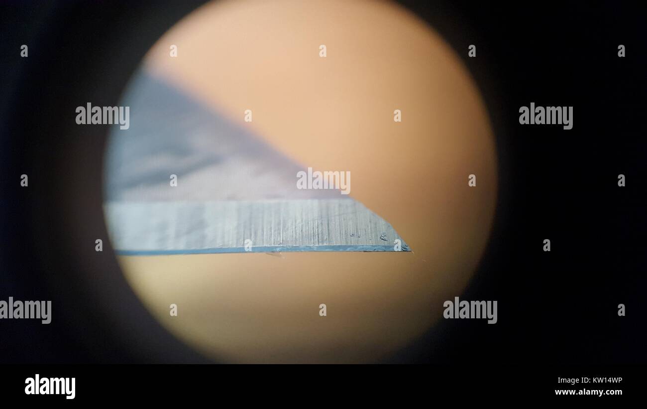 Light microscope image at approximately 30x magnification showing the tip of a razor blade, 2016. Stock Photo