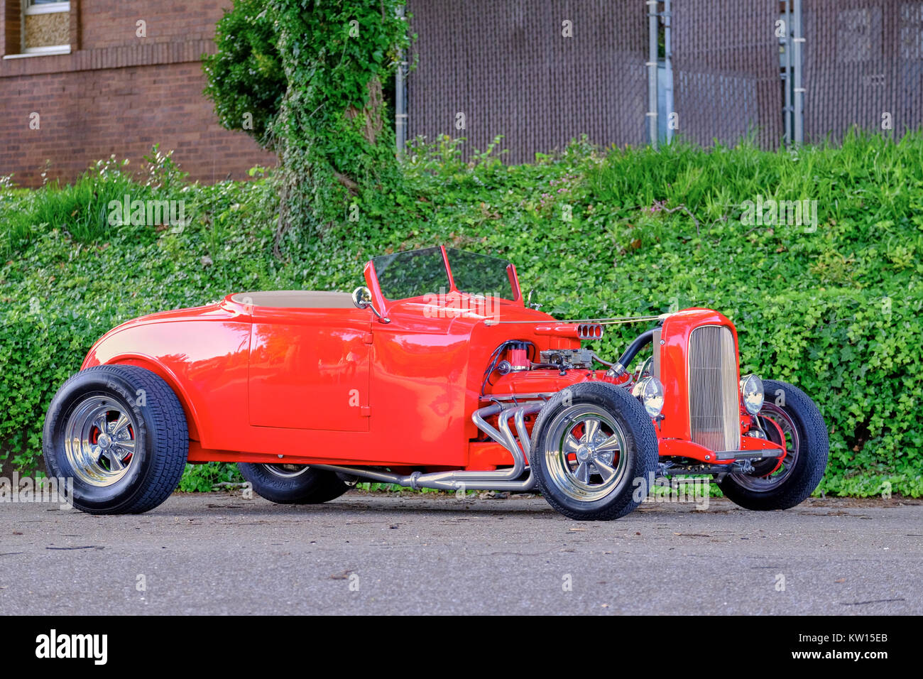 1932 red Ford hot rod roadster on side view display showing open engine compartment. Stock Photo