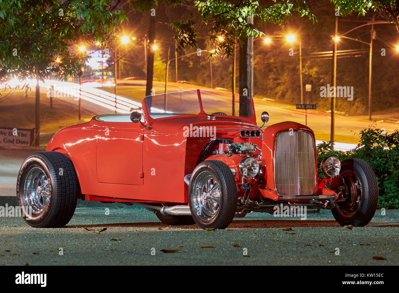 1932 red Ford hot rod roadster on side view display showing open engine compartment. Stock Photo