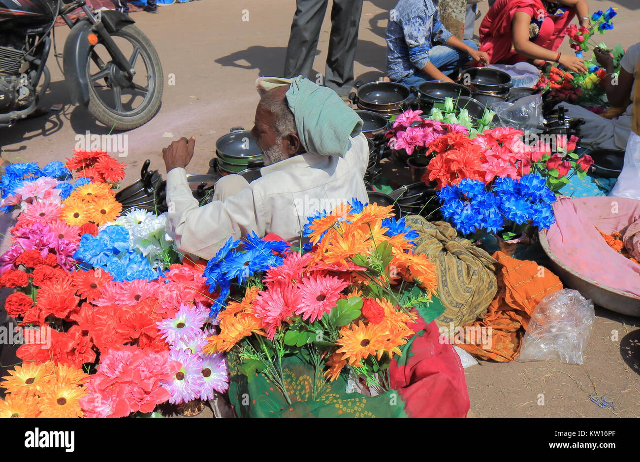 Indian man sells flowers and cooking pots at Sardar street market in