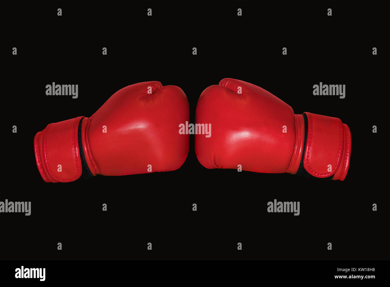 Red Boxing gloves isolated on black background. Two Boxing gloves to each other. Stock Photo