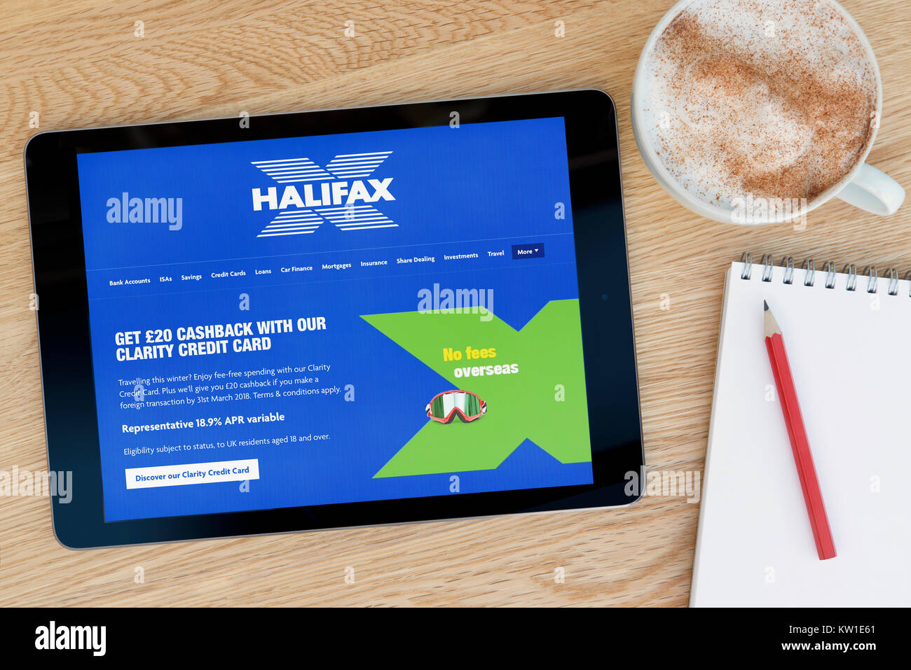 The Halifax Building Society website on an iPad tablet device, resting on a wooden table beside a notepad, pencil and cup of coffee (Editorial only) Stock Photo
