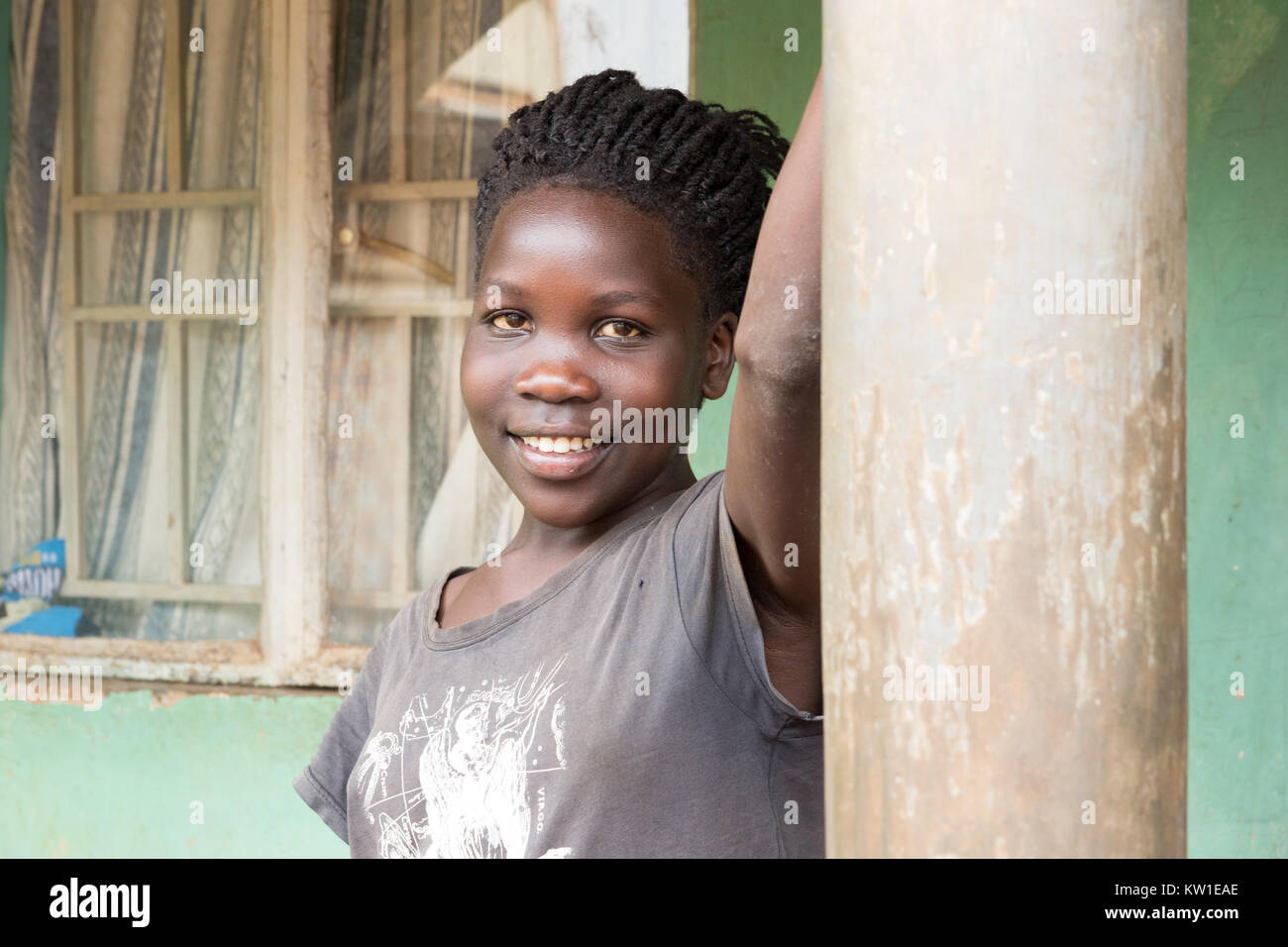 A young African girl leaning against a column. Stock Photo