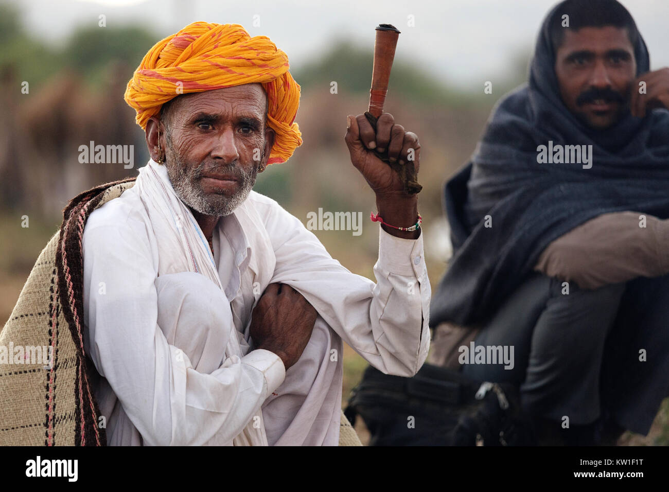 Scene at Pushkar Camel Fair, men in their morning routine bu the fireplace, smoking, Pushkar, Ajmer, Rajasthan, India Stock Photo