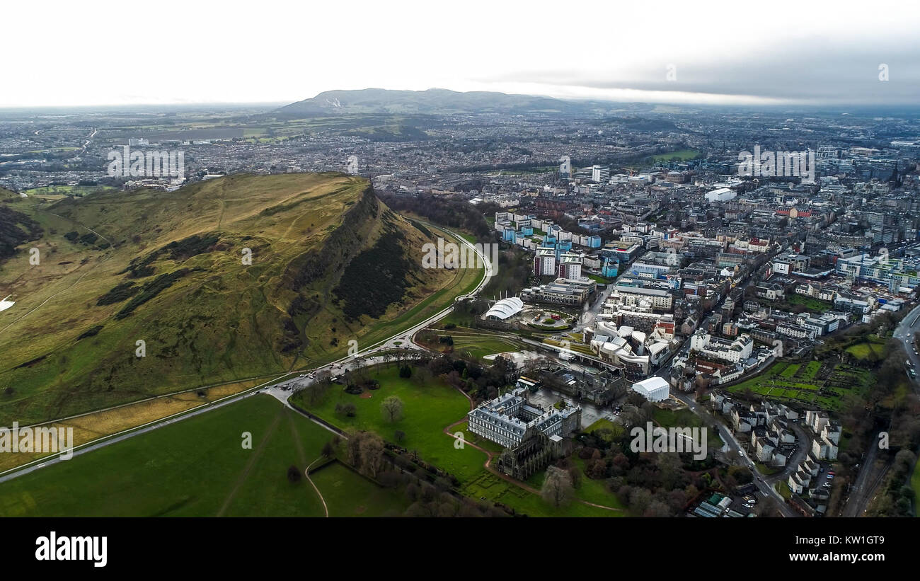 Aerial View Flying by Iconic Landmarks in Edinburgh Famous Arthur's Seat Hill, Modern Scottish Parliament Building, Holyrood Park, Palace in Scotland Stock Photo