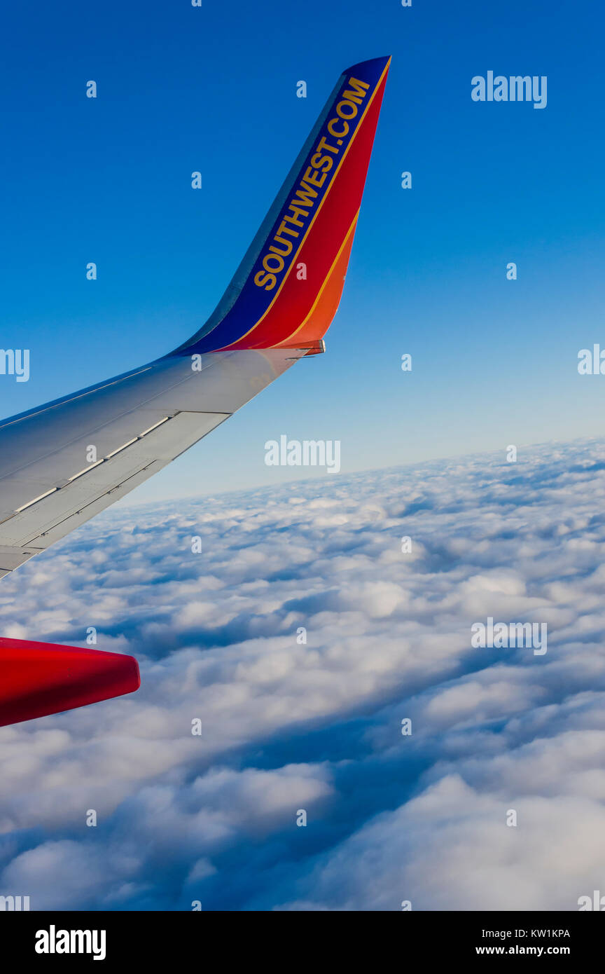 Southwest Airlines jet with a bed of white clouds beneath Stock Photo