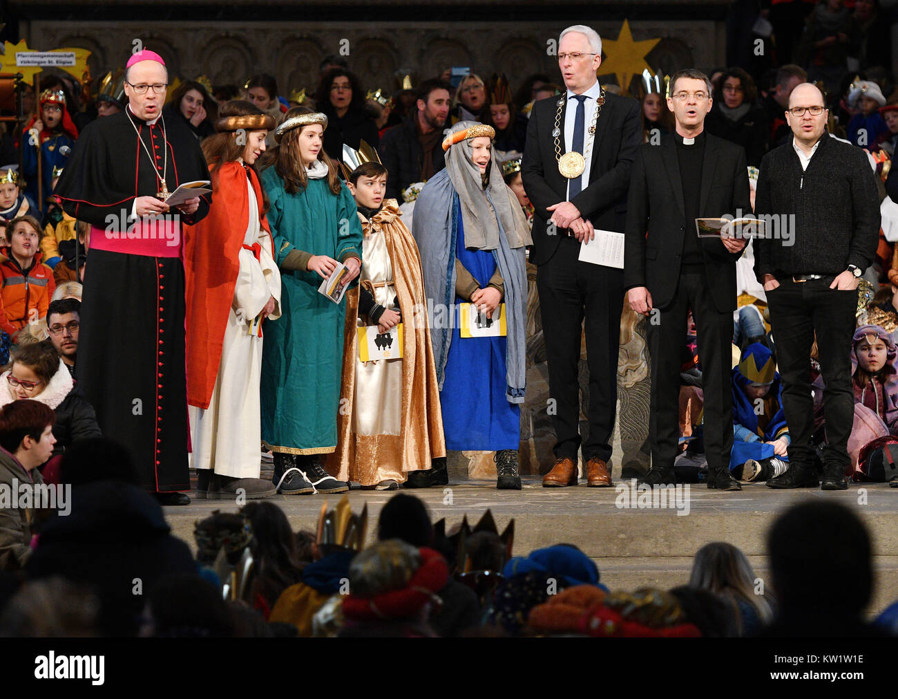 Trier, Germany. 29th Dec, 2017. The bishop of Trier Stephan Ackermann (L-R) sings together with carol singers, the mayor of Trier Wolfram Leibe, prelate Klaus Kraemer (president children mission service) and pastor Dirk Bingener (Spiritual Advisor Union of Catholic Youth) during the nationwide start of the ·Dreikoenigssingen· (lit. three wise men singing) event in the cathedral in Trier, Germany, 29 December 2017. On the occasion of Epiphany (6 January) children collect for other children in need. Credit: Harald Tittel/dpa/Alamy Live News Stock Photo