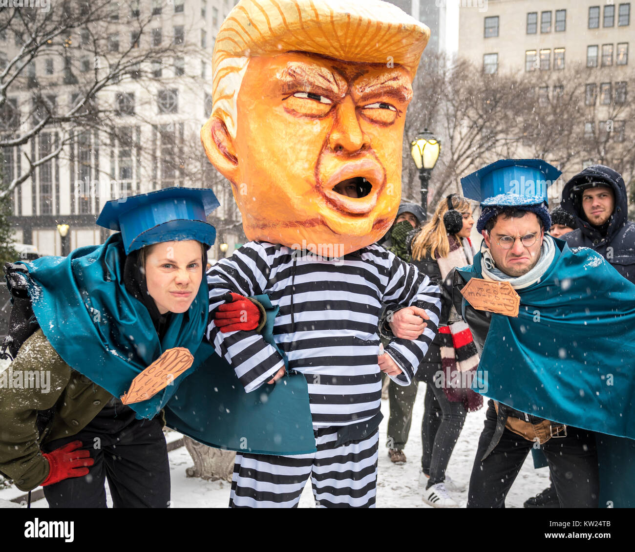 New York, USA, 30 Dec 2017.  Protesters representing New York policemen pretend to detain another demonstrator wearing a mask mocking a chained US President Donald Trump on a jail uniform, as they perform next to New York city's Plaza Hotel .  Demonstrators braved a snowstorm to demand Trump's impeachment. Photo by Enrique Shore/Alamy Live News Stock Photo