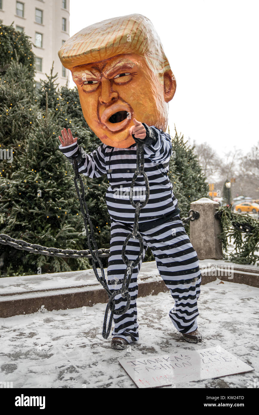 New York, USA, 30 Dec 2017.  A protester wearing a mask mocking a chained US President Donald Trump on a jail uniform performs in front of New York city's Plaza Hotel .  The sign reads (Trump's daughter) "Ivanka's New Fashion Line" #Impeach Trump. Demonstrators braved a snowstorm to demand Trump's impeachment. Photo by Enrique Shore/Alamy Live News Stock Photo