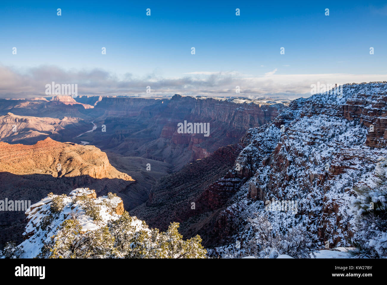 The Wintery rim of Navajo Point looks east past the Desert View Watchtower and over the Grand Canyon at sunrise. Stock Photo