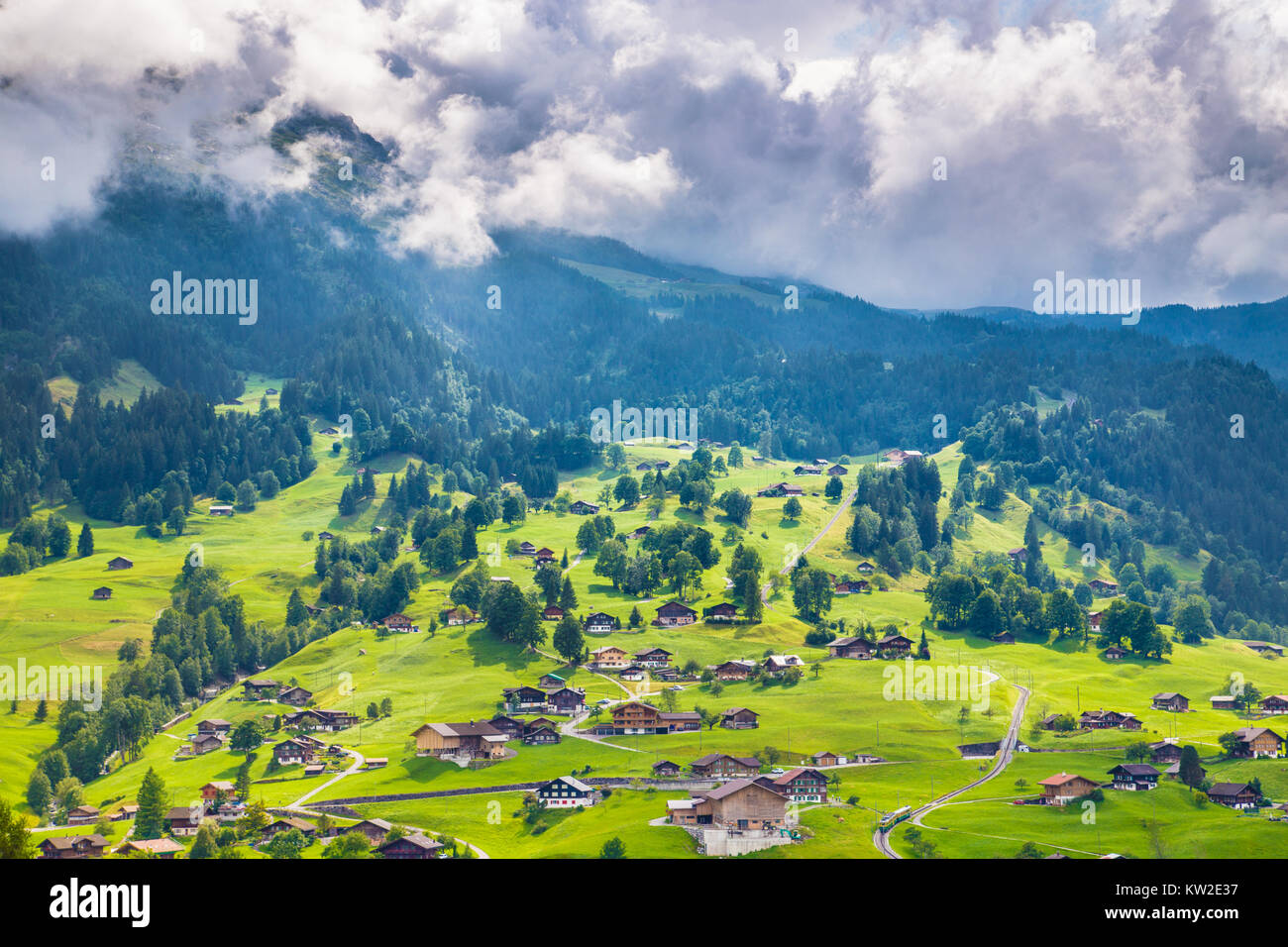 Beautiful view of idyllic mountain scenery in the Alps with old chalets in fresh green meadows, Grindelwald, Bernese Alps, Switzerland Stock Photo