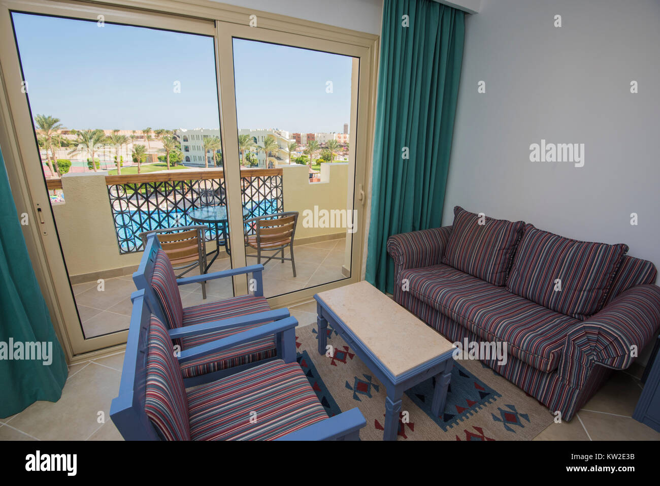 Lounge area in luxury hotel resort room with patio door and balcony view Stock Photo