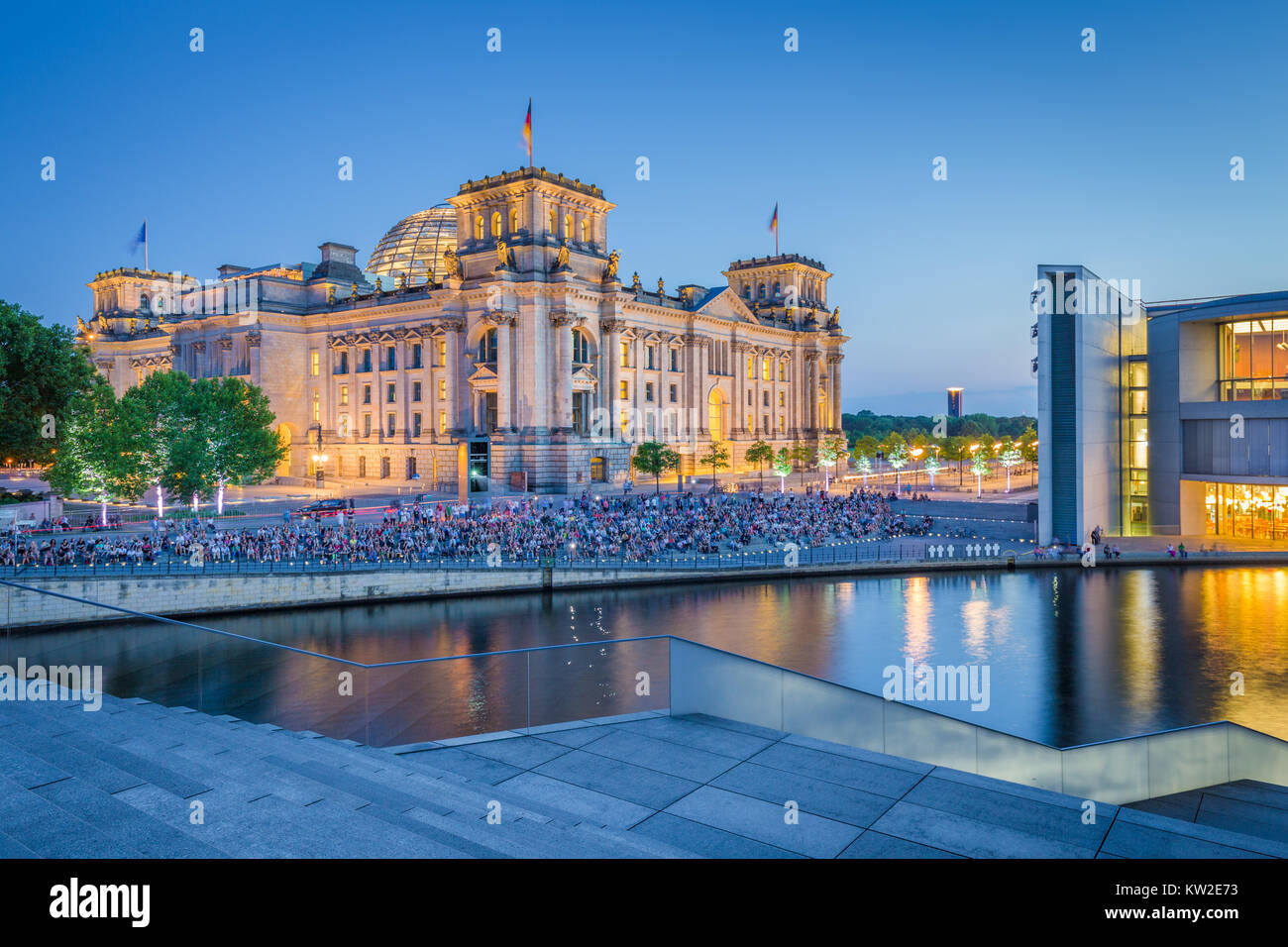 Panoramic view of modern Berlin government district with famous Reichstag building and Spree river illuminated in beautiful post sunset twilight Stock Photo