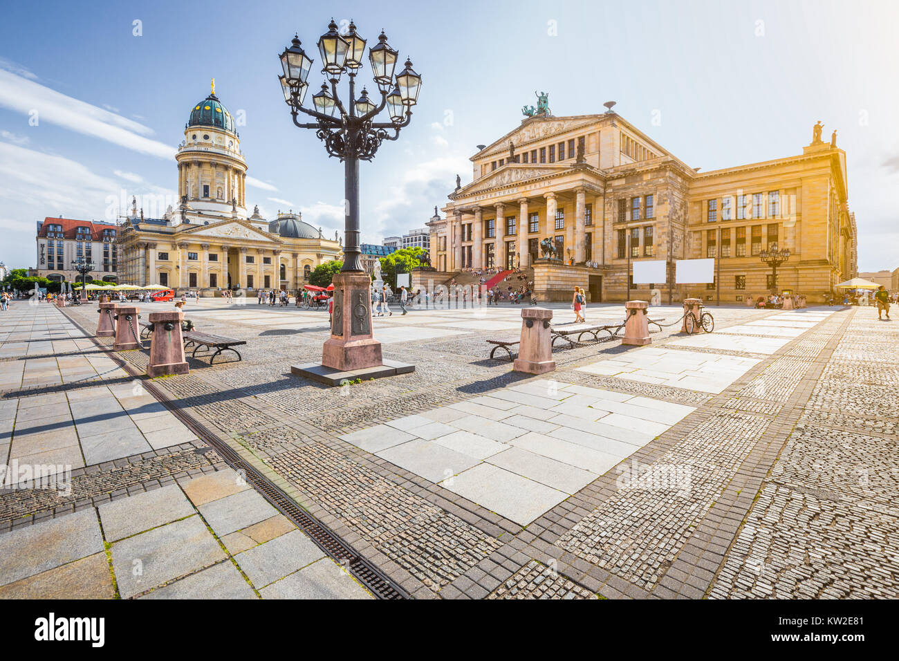 Panoramic view of famous Gendarmenmarkt square with Berlin Concert Hall and German Cathedral in golden evening light at sunset with blue sky and cloud Stock Photo