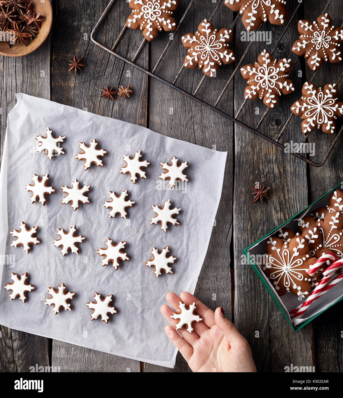 Woman cooking Christmas gingerbread stars on rustic wooden background Stock Photo