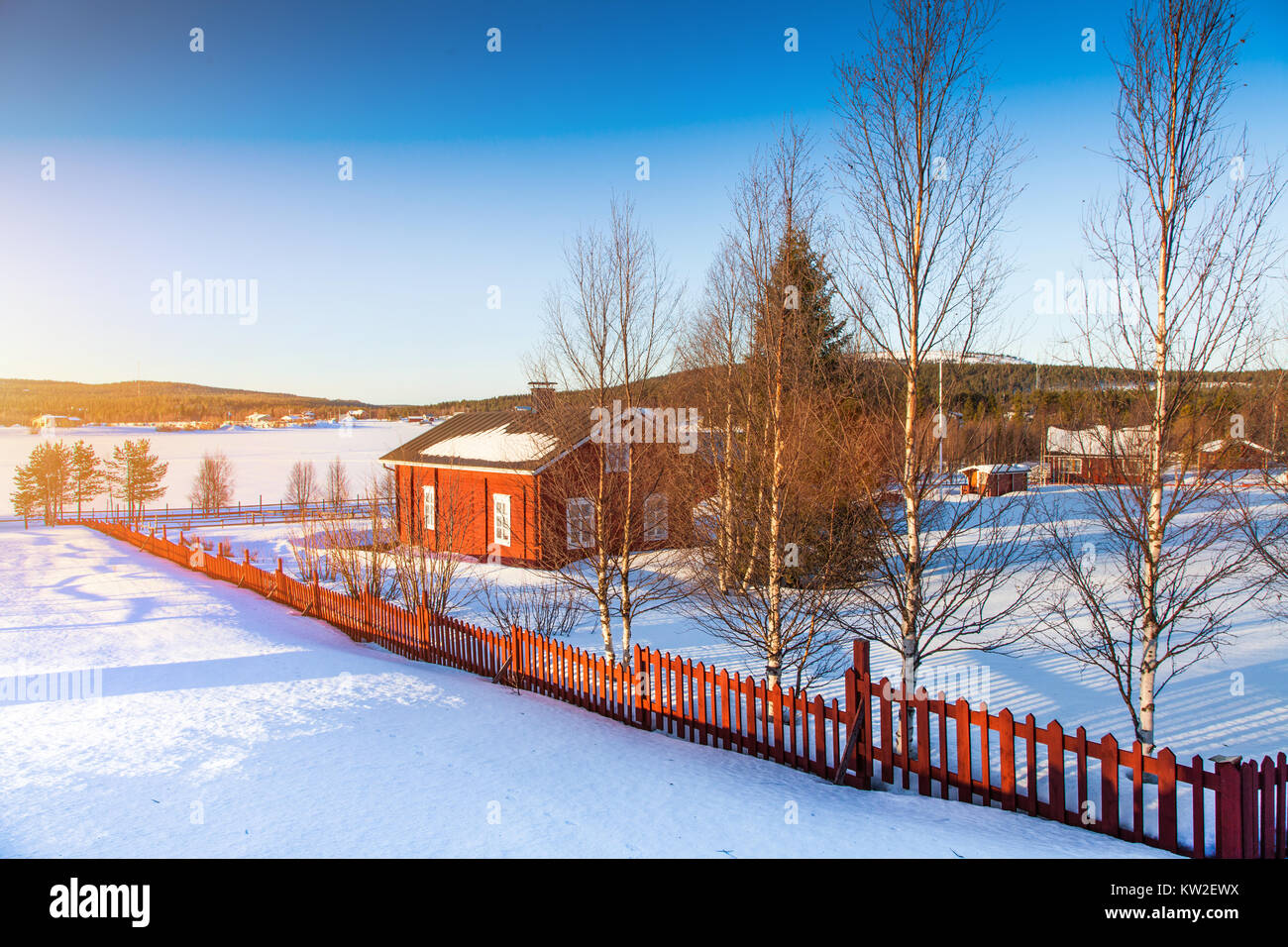 Beautiful winter landscape with house at frozen lake in Scandinavia at sunset Stock Photo