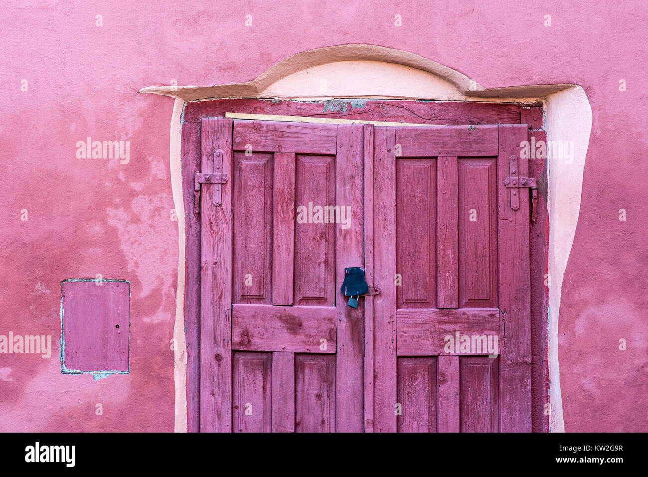 Rustic pink wooden door on old pink house Stock Photo