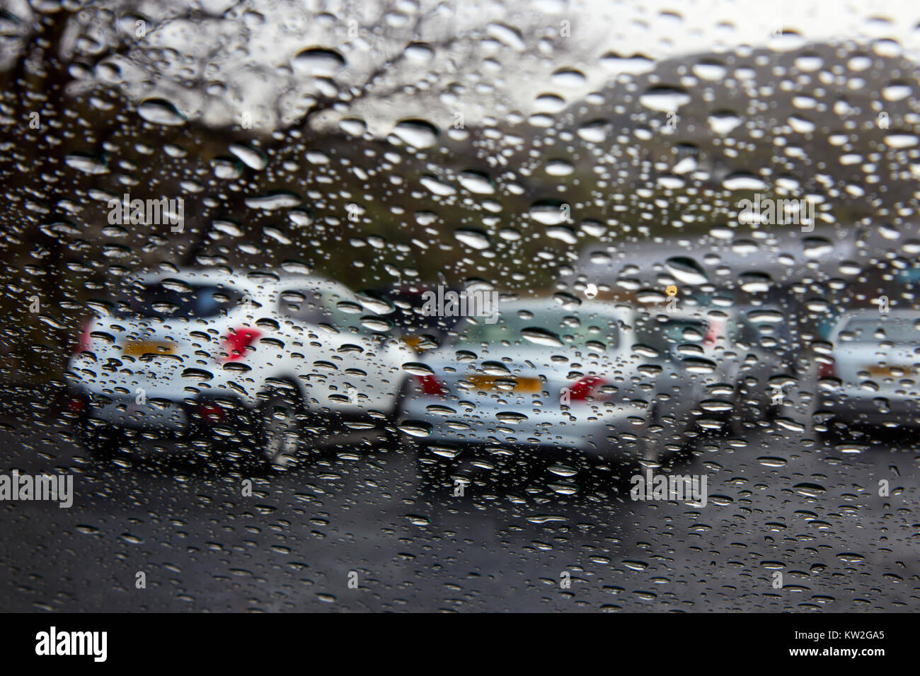 View from the inside of the front seat of a car through a wet window
