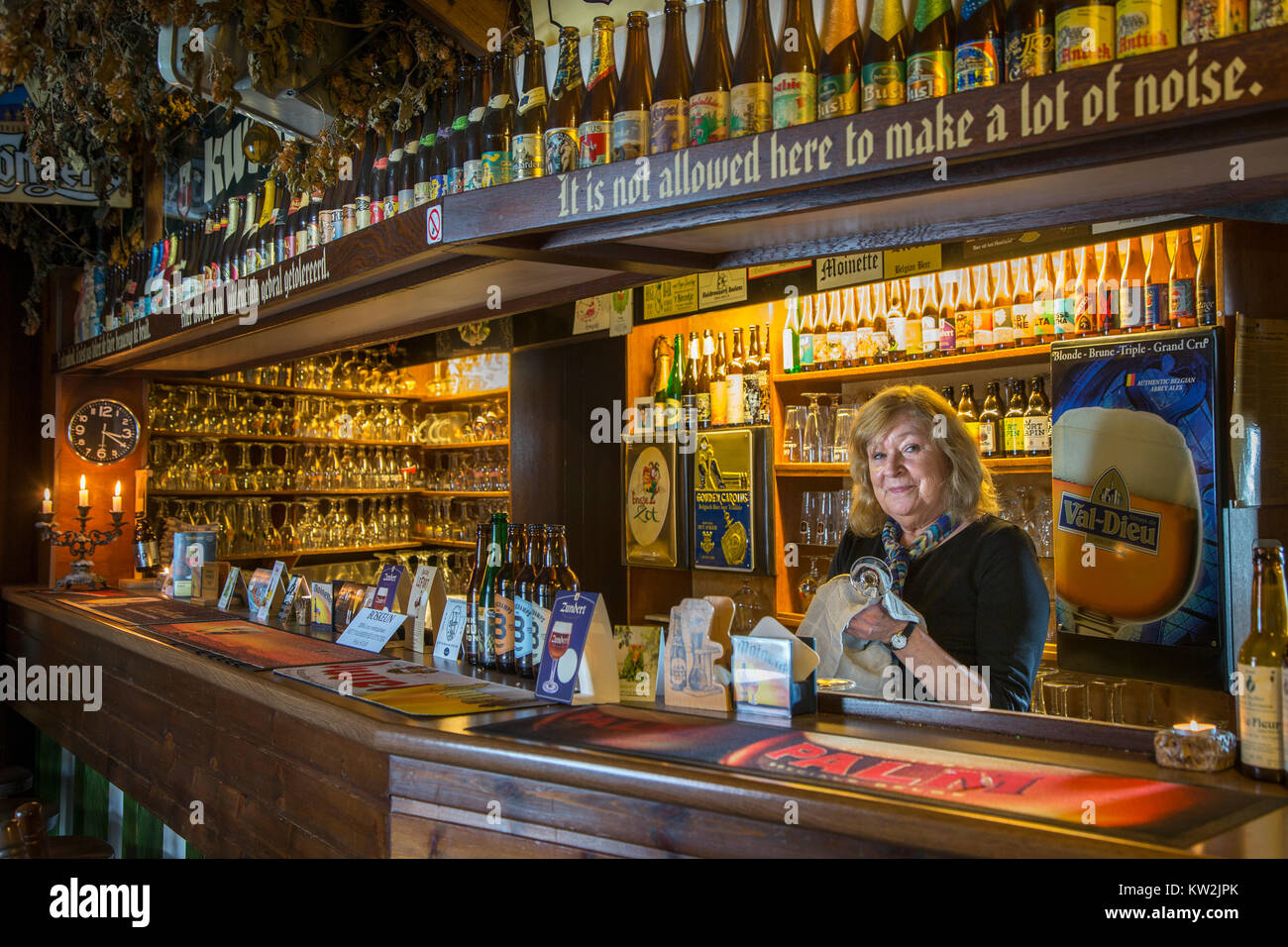 Female bartender behind bar counter in tavern Kroegske, Belgian café-restaurant in the village Emelgem, Izegem, West Flanders, Belgium Stock Photo