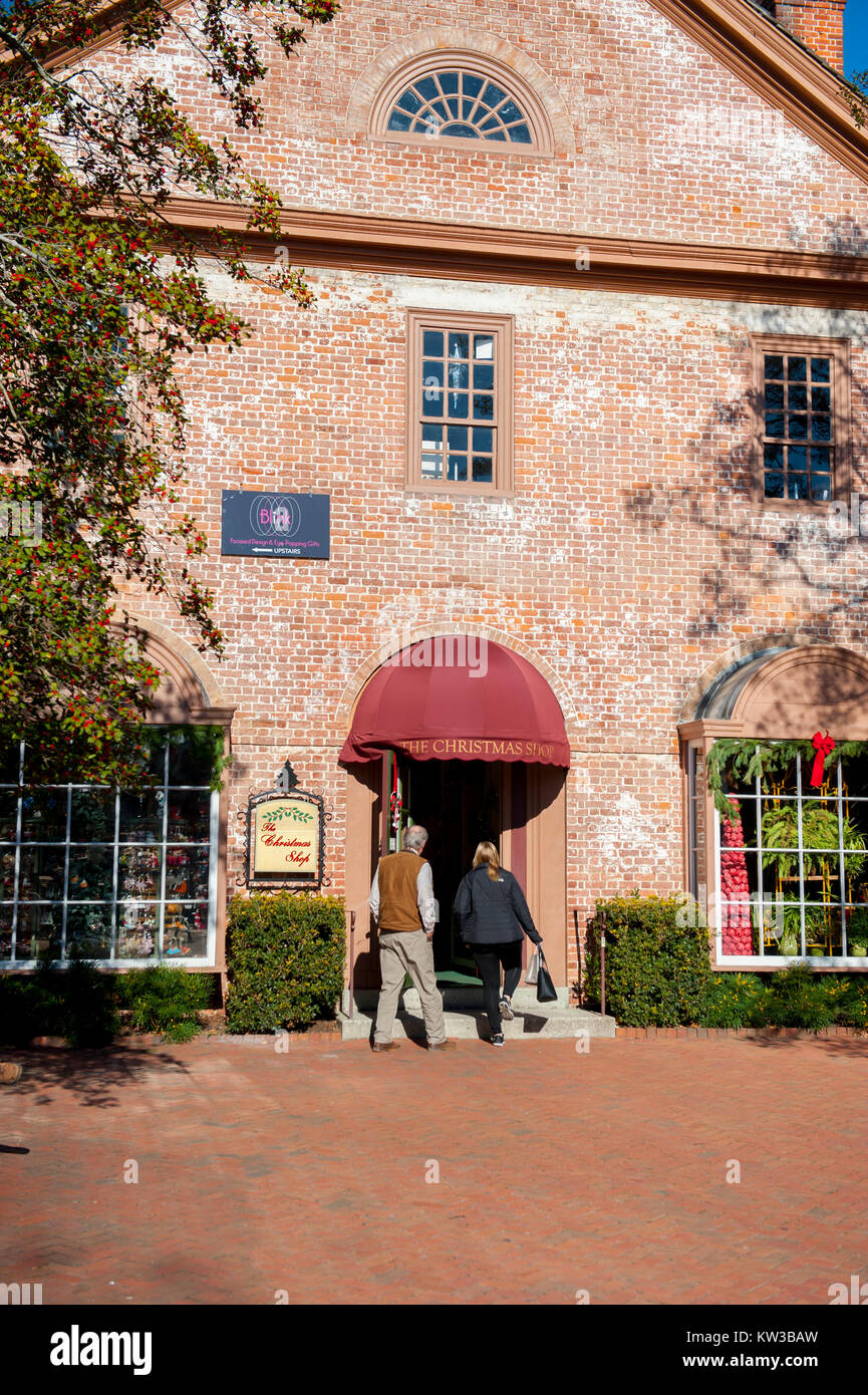 USA Virginia VA Colonial Williamsburg Merchants Square on Duke of Gloucester Street a couple going in the Christmas Shop  winter Christmastime Stock Photo