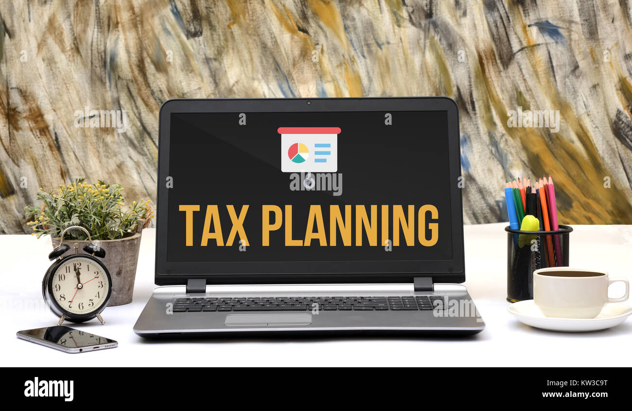 Tax Planning icon on laptop screen in office. Stock Photo