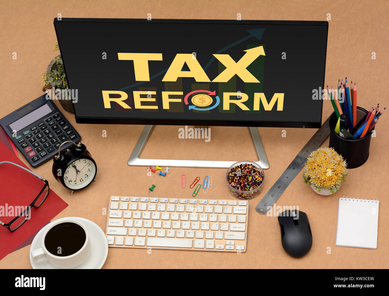 Tax Reforms with arrow going up office monitor top view. Stock Photo