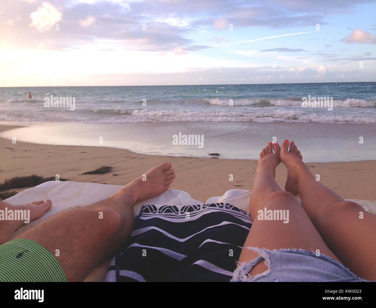 Couple sunbathing and relaxing on a beach Stock Photo