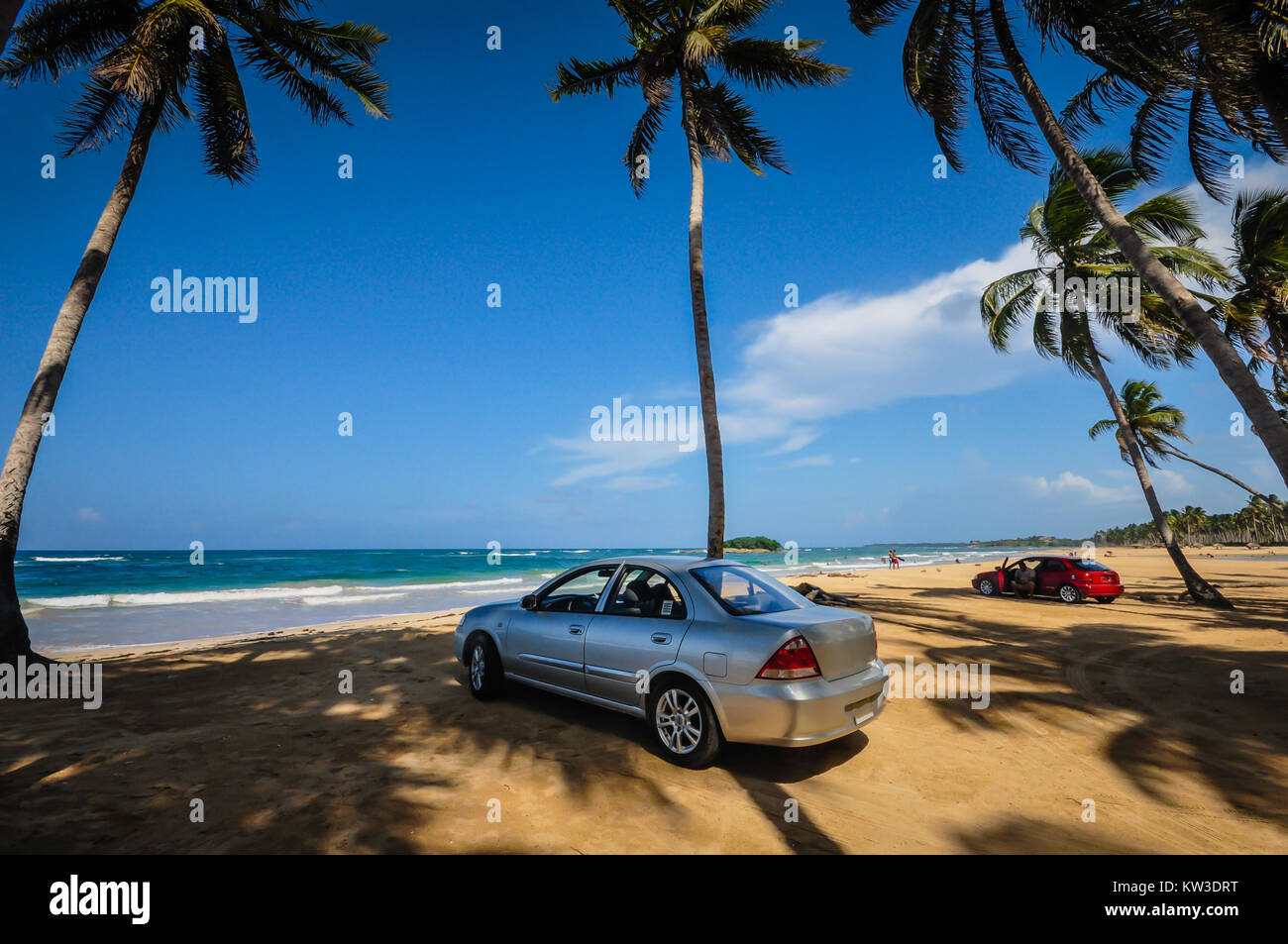 Silver and red sedan cars parked on Playa Grande in the Dominican