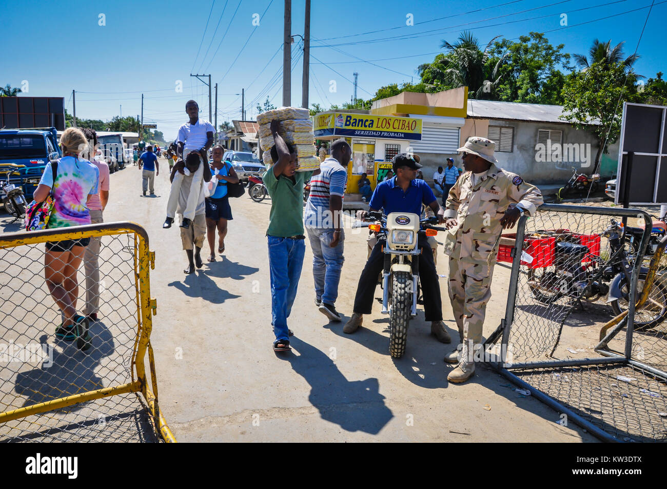 Border patrol agent and fence at Ounaminthe, Haiti on border of Dominican Republic. Stock Photo