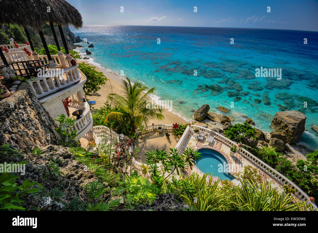 Stunning aerial ocean view of balconies, round pool, and clear ocean at a Caribbean resort. Stock Photo