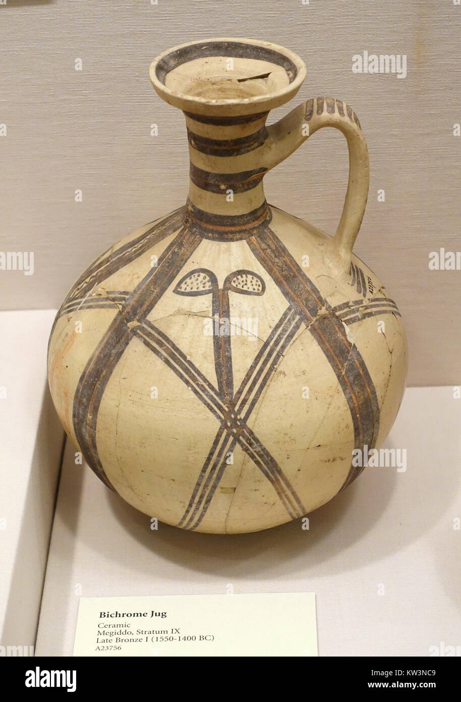 A bichrome ceramic jug from Megiddo, dating to the Late Bronze Age I (1550-1400 BC), displayed at the Oriental Institute Museum, University of Chicago. The jug features two-tone coloring and intricate craftsmanship. Stock Photo