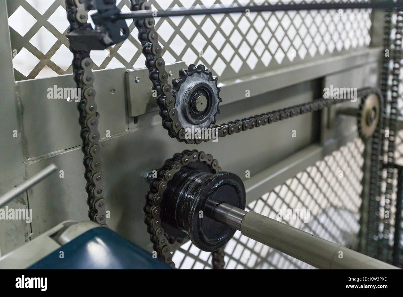 Triple strand roller chain going around three sprockets on industrial