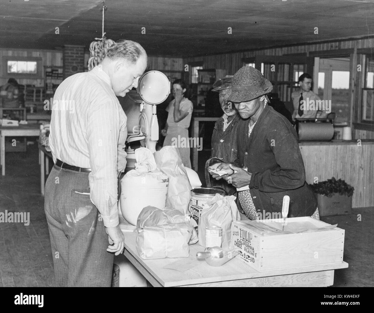 Men look at various goods for sale at a cooperative store in La Forge, Missouri, May, 1938. From the New York Public Library. Stock Photo