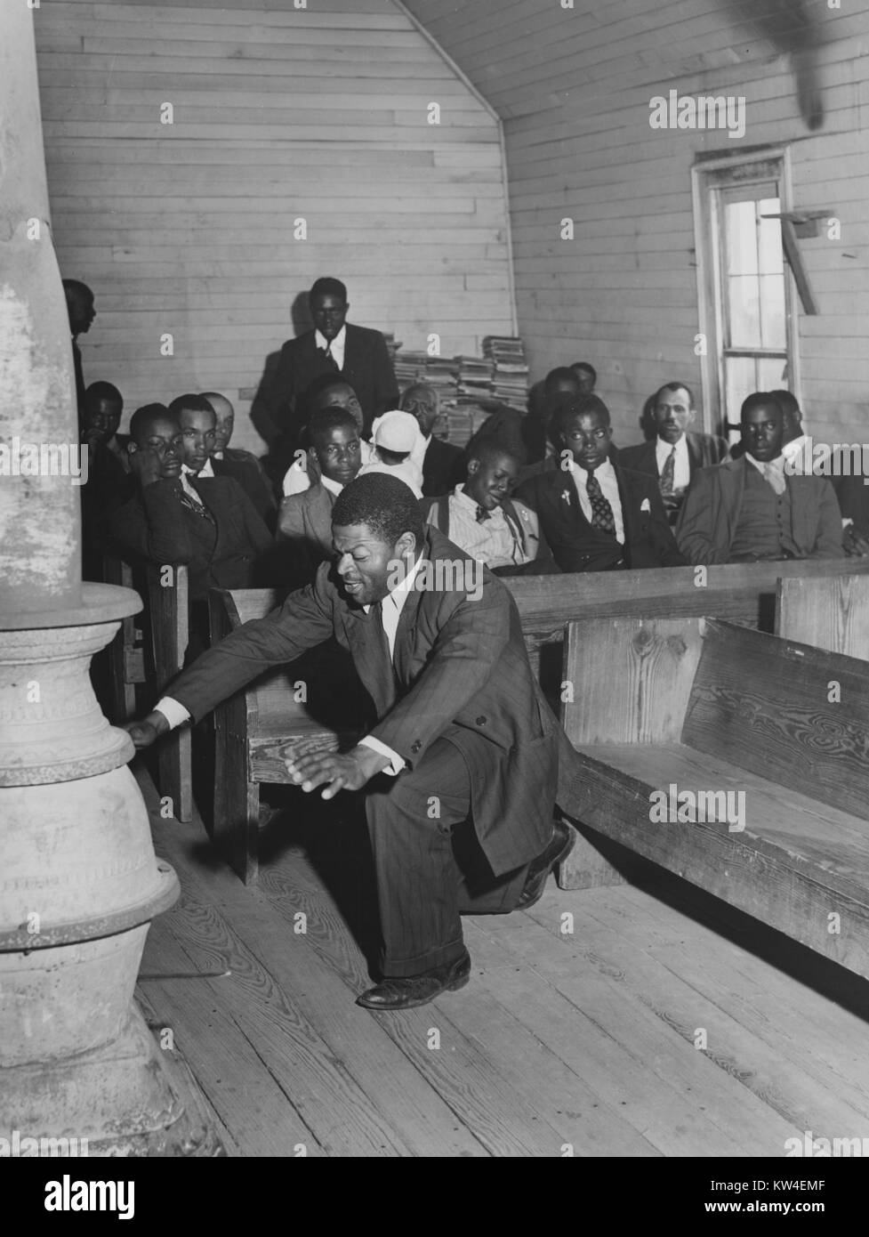 Man kneeling during religious gathering in African American church, singing 'trying to make a hundred, ninety-nine and a half won't do', heard county, Georgia, USA, April, 1941. () Stock Photo