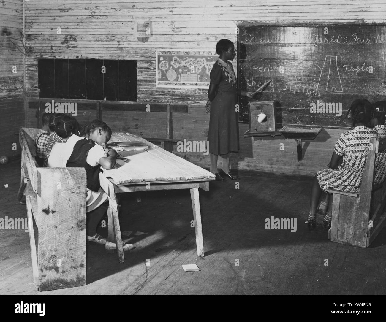 A woman teaches a class of children in a school on the Mileston