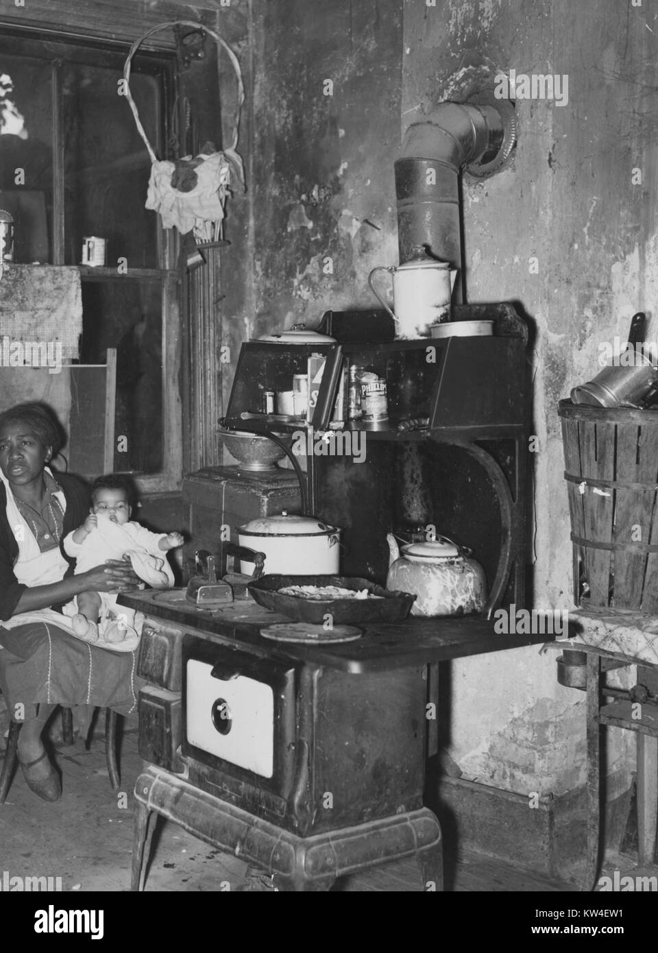 African american mother and child in a slum kitchen, Washington, DC, 1937. From the New York Public Library. Stock Photo