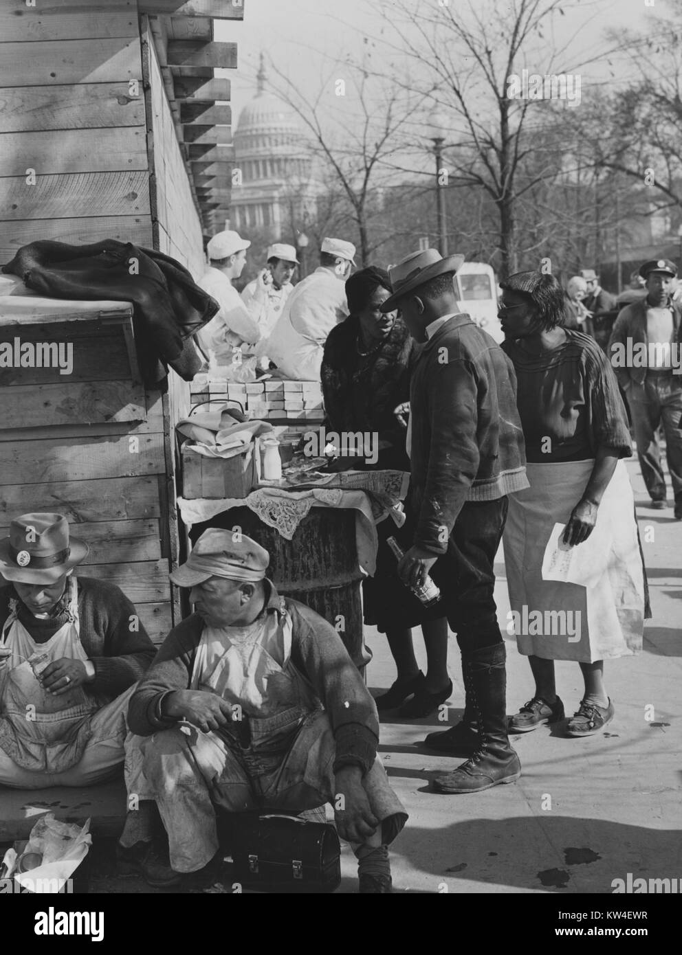 Hot lunches are served on the job by African-American vendors; Soups, beans, and coffee were their menu, with occasional corn bread and succotash; Emergency office space construction, Washington, DC, 1939. From the New York Public Library. Stock Photo
