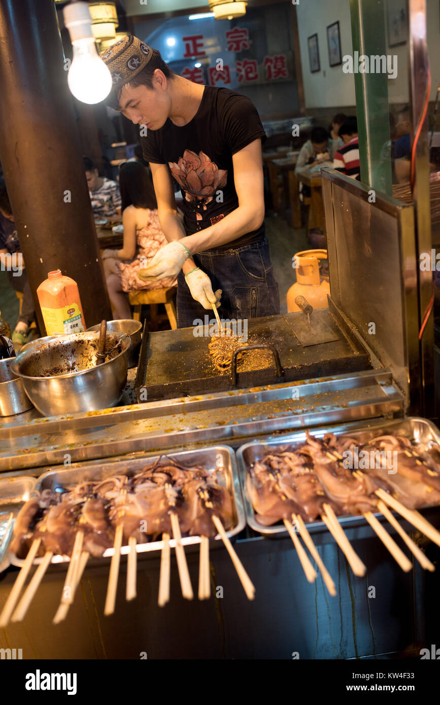 Vendors at the Muslim Quarter in Xi'an. Today's night market at Huimin Street was founded a thousand years ago by merchants of the ancient Silk Road. Stock Photo