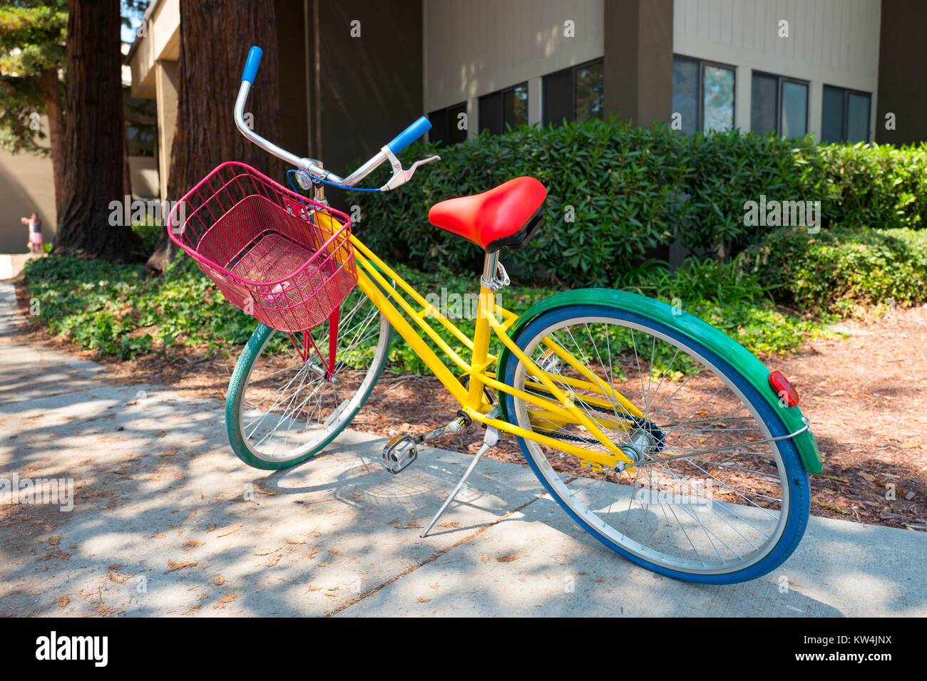 Colorful Google Bike parked in front of a building at the Googleplex, headquarters of the search engine company Google in the Silicon Valley town of Mountain View, California, August 24, 2016. Employees are encouraged to ride the free bikes around Google's campus, and to leave them in front of Google buildings once they arrive at their destination, Mountain View, California. Stock Photo