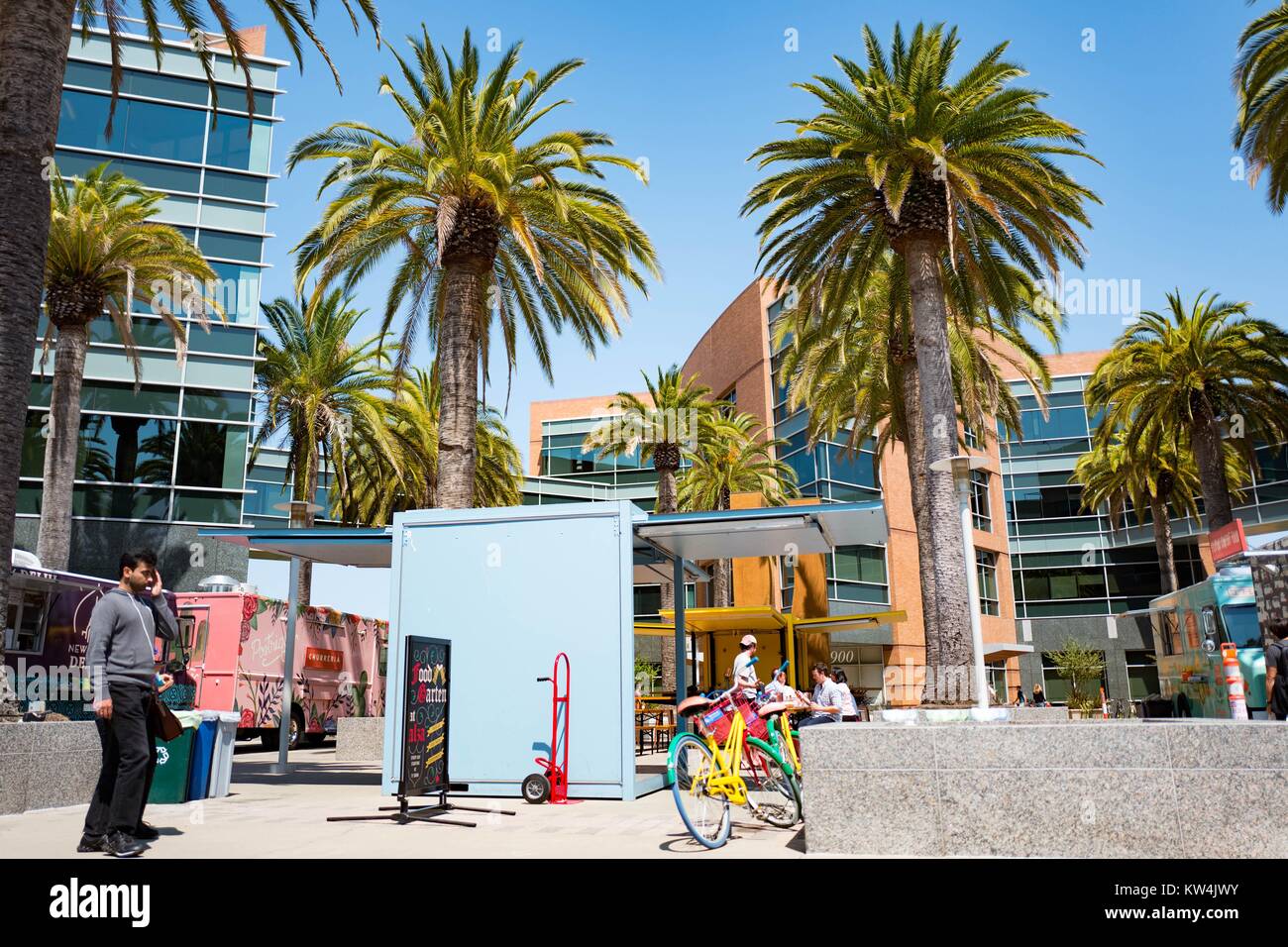 At the Googleplex, headquarters of the search engine company Google in the  Silicon Valley town of Mountain View, California, a colorful Google Bike is  parked near food trucks, with palm trees and