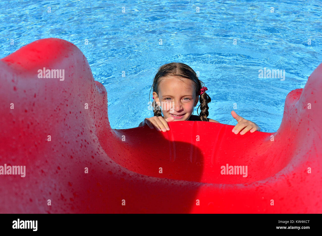 Little girl in swimmingpool with slides.. Swimming pool slides for