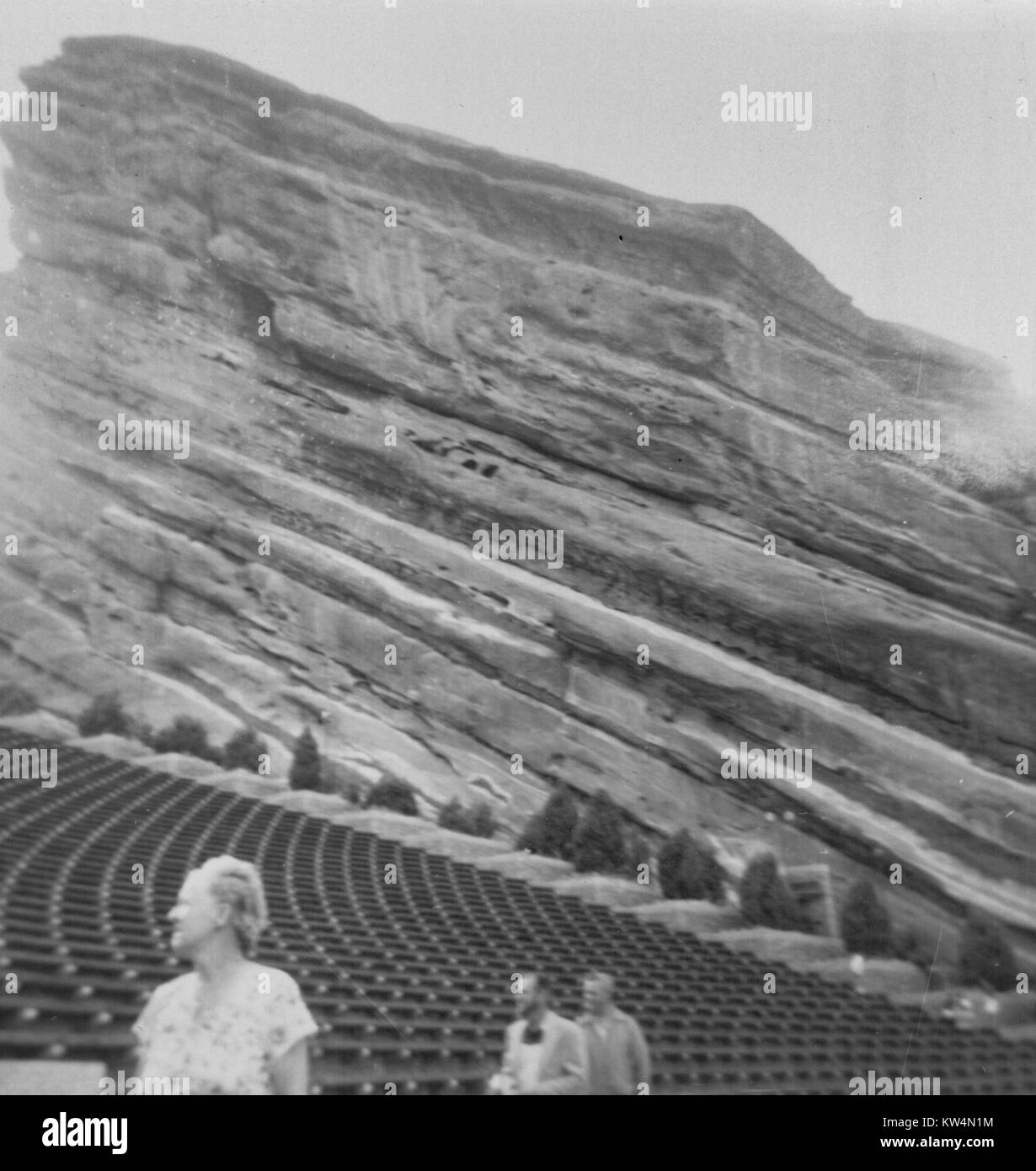 Tourists walk past seats at Red Rock Amphitheatre, a concert venue carved into a rocky cliff face in Colorado, 1958. Stock Photo