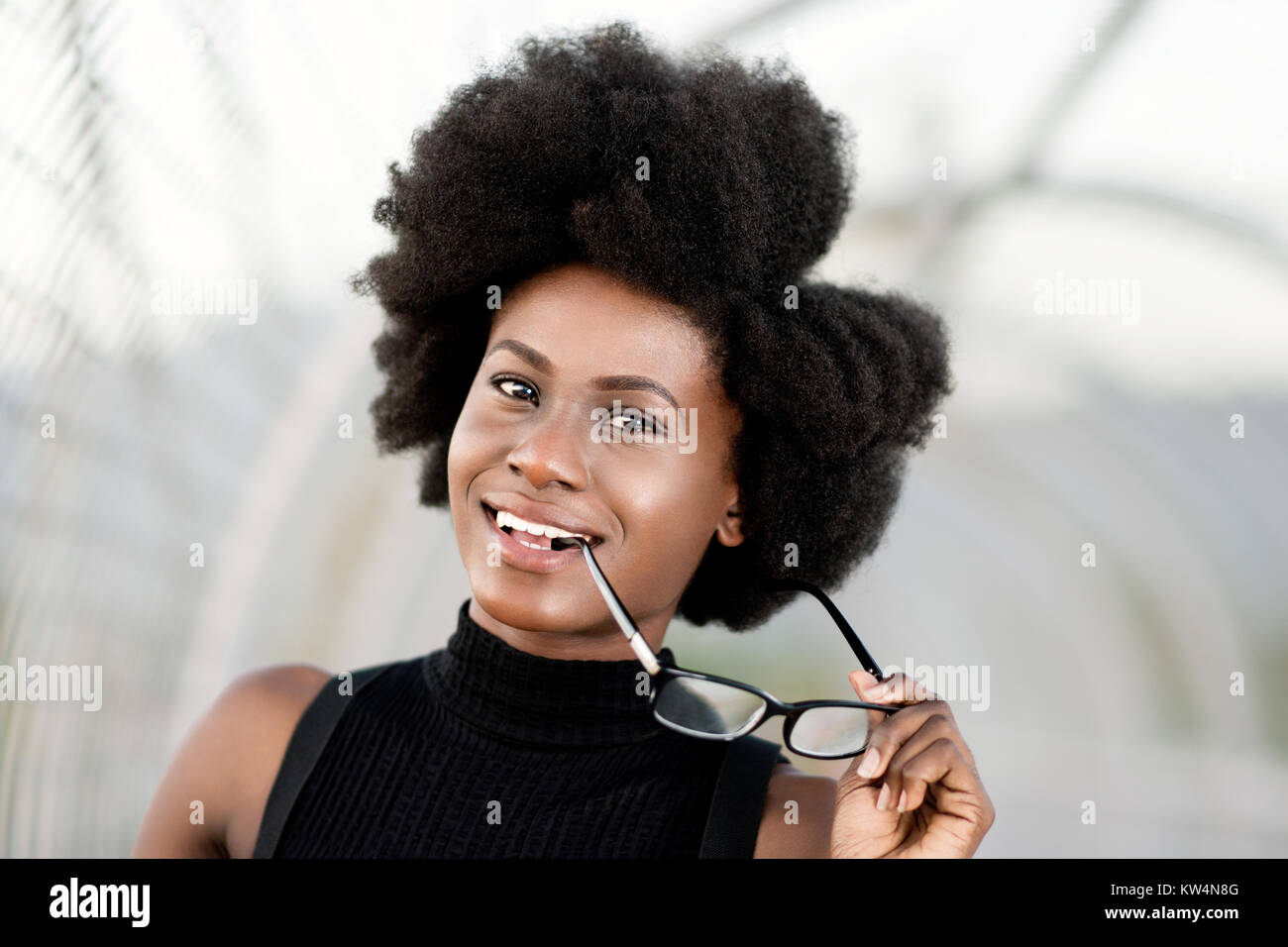 Black Woman With Natural Hair Holding A Glasses Smiling Stock