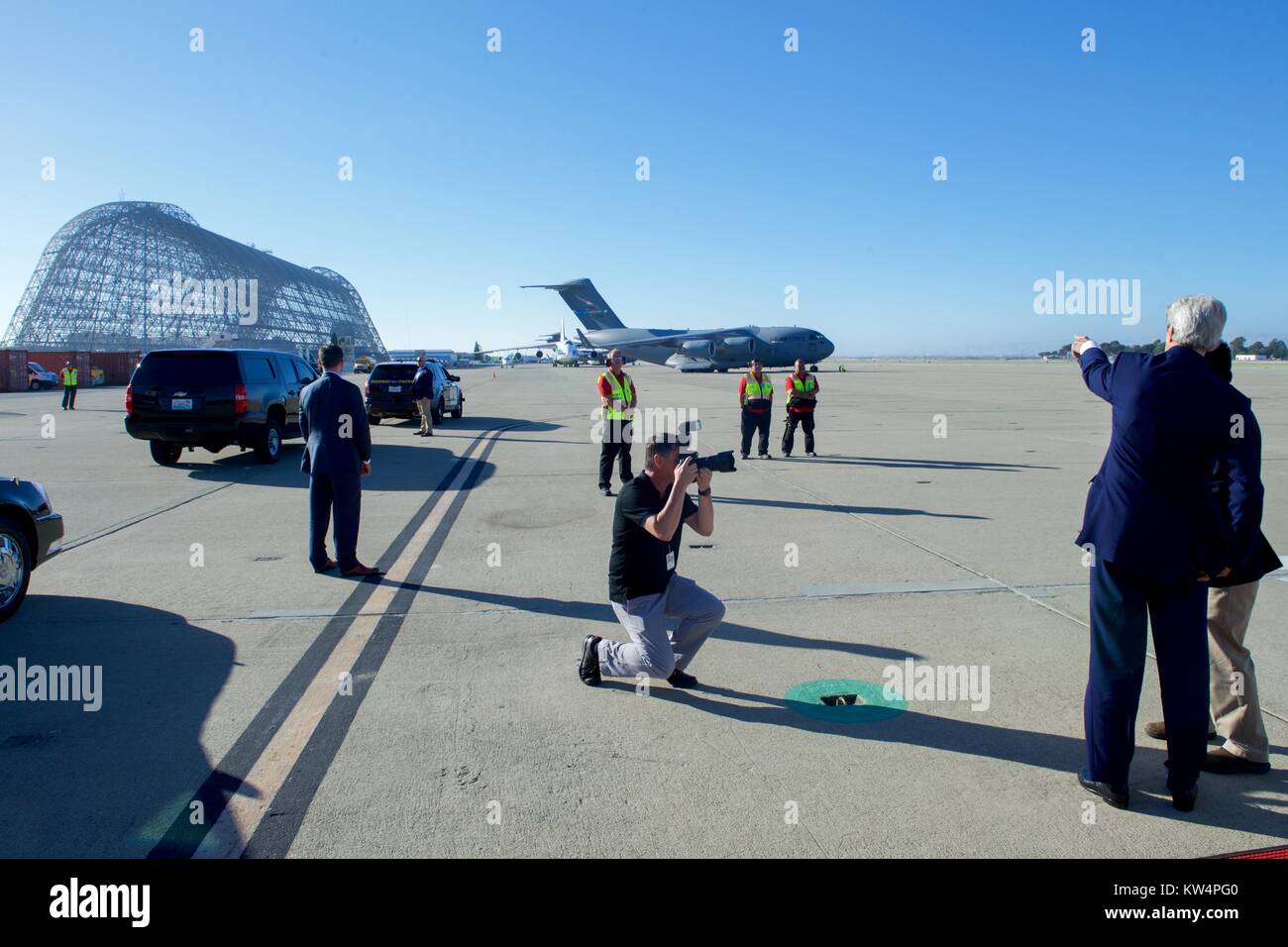 US Secretary of State John Kerry points to the skeleton of Hangar One after landing at Moffett Field in Mountain View, California, following a flight from Andrews Air Force Base in Camp Springs, Maryland, so he can attend events around the Global Entrepreneurial Summit at Stanford University in Palo Alto, California, June 22, 2016. Image courtesy US Department of State. Stock Photo