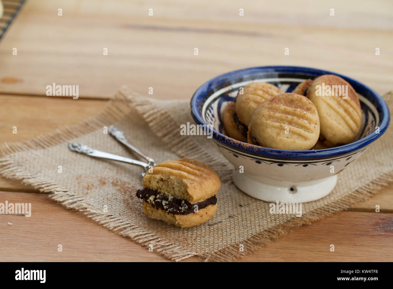 Chocolate filled melting moments on wooden table Stock Photo