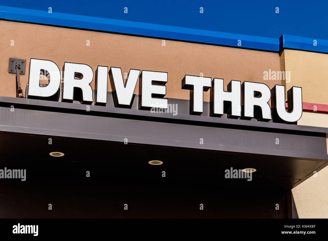 White and Blue Drive Thru sign set against a blue sky I Stock Photo