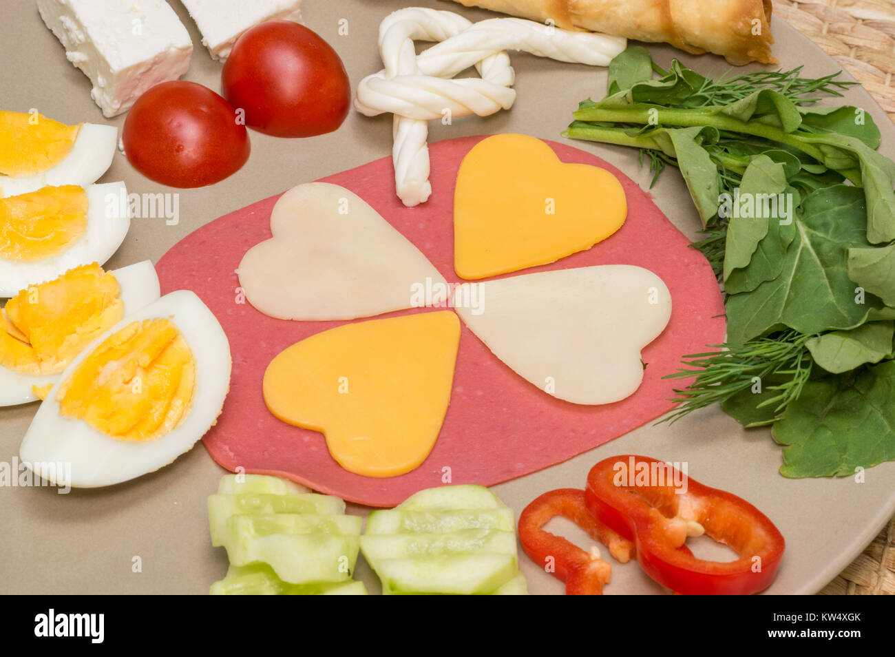Close up of traditional Turkish breakfast served on porcelain plate with cheese, salami, boiled egg, tomato, and cucumber Stock Photo