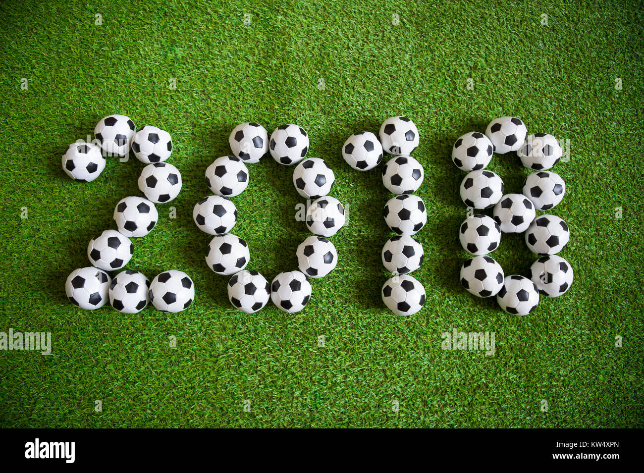 Message for new year 2018 formed from little balls on green football sports pitch Stock Photo