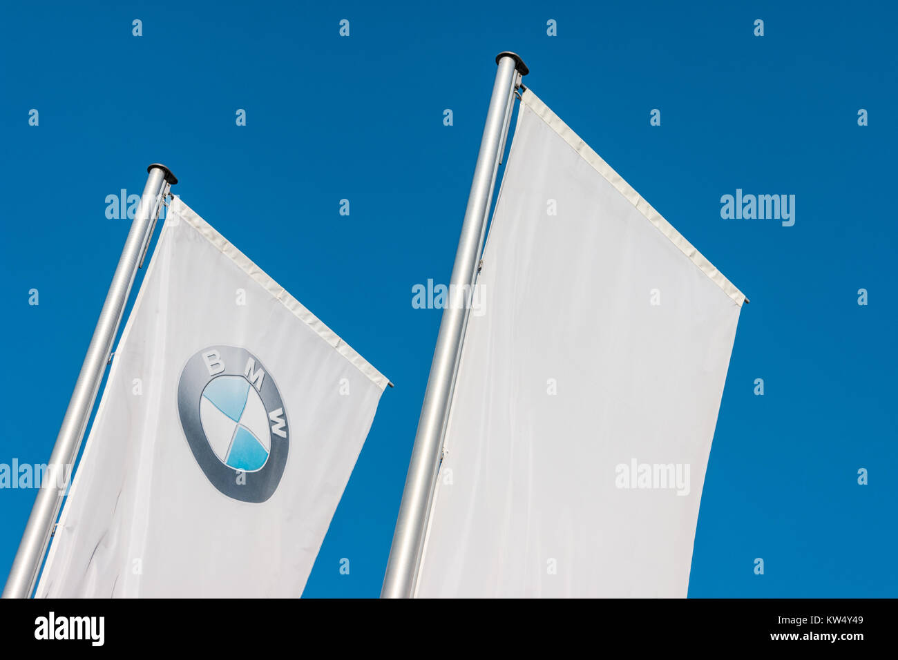 Sign of a BMW logo on white flags. BMW is a vehicle, motorcycle, and engine manufacturing company from Munich, Bavaria, Germany. Stock Photo